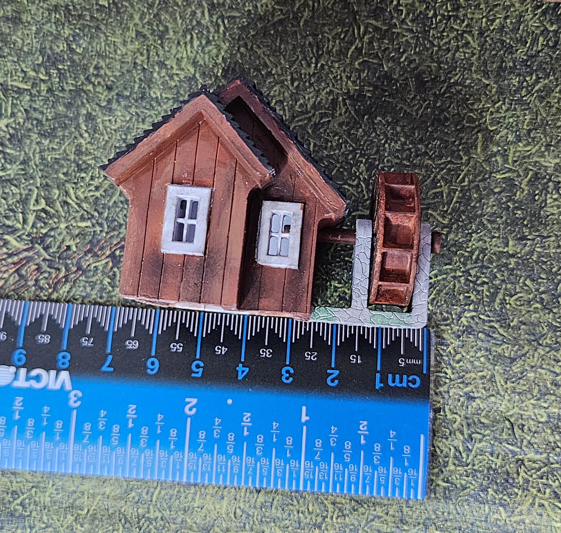 Width view of HO scale waterwheel with small building